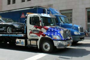 A tow truck with a car on its bed on the streets of Texas